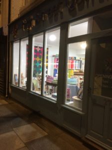 a night-time picture of the outside of the high street quilting shop